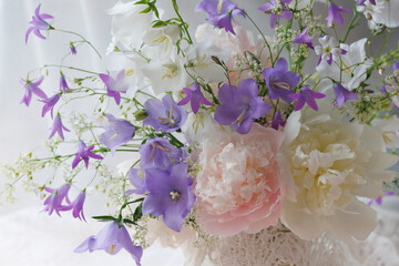 Bouquet of flowers peonies, white and blue bells, gypsophila, fragment, close-up, beautiful postcard