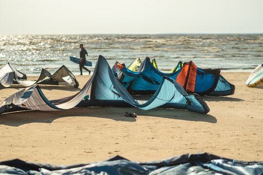 Kite surfing at beach by sea with colorful inflatable kites waiting for competition. Surfers preparing in background during summer, tourism and travel active recreation, sports leisure activity