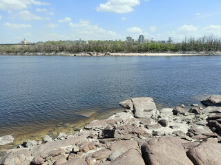 View from the rocky shore of Khortytsia Island to the buildings of Zaporizhzhia and the Dnieper Dam on the opposite bank of the river.