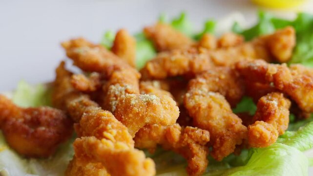 Golden fried pork strips rest atop fresh lettuce&mdash;showcasing crunchy texture, savory warmth, and vibrant plating of a beloved Chinese delicacy.