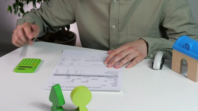 Close-up of male hands checking an estimate and recalculating it on a calculator. Financial and economic activity audit, checking estimates and expenses.