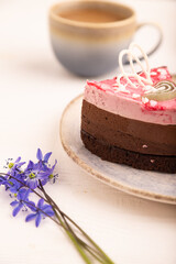 Chocolate cake on white wooden, orange linen textile, cup of coffee, side view, close up, selective focus