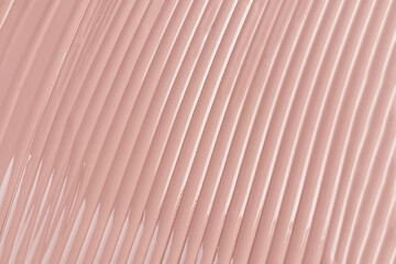 A sample of liquid foundation in a natural tone. delicate parallel stripes of foundation with...