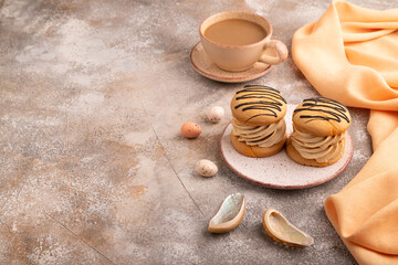 Caramel Cream Cakes on brown concrete, cup of coffee, side view, copy space