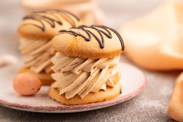 Caramel Cream Cakes on brown concrete, cup of coffee, side view, close up, selective focus