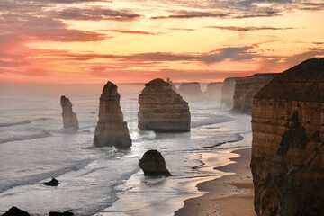 The iconic Twelve Apostles stand tall against the rugged coastline of the Great Ocean Road,...