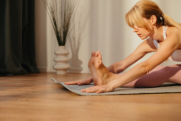 Young female stretching in a bright, light-filled studio