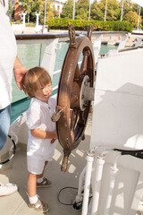 A man and a boy on a white boat in the sea are sitting by the side, father and son are enjoying a sea trip