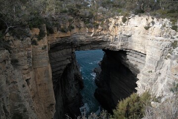 The impressive Tasman Arch, a natural rock formation on Tasmania's coast. The image highlights the...