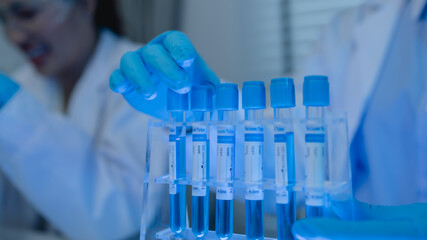 when in a lab, scientists wear lab coats, rubber gloves, and safety goggles, two chemists are testing chemicals in a liquid state, chemists working in a laboratory