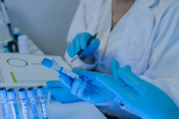 two scientists consult each other while conducting an experiment on a liquid substance in a...