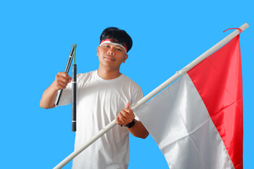 Young Man Holding Indonesian Flag and Traditional Weapon