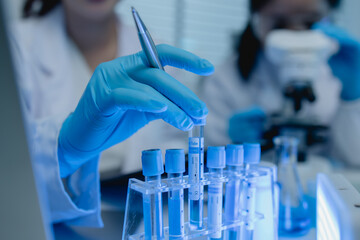 a female chemist is testing various liquid compounds in a lab, a scientist is doing research on the...