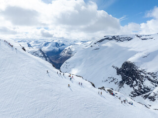 Alpine skiers in mountain, on the way to the top. Group of downhill skiers on a slope on a bright...