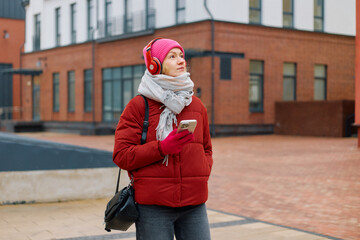 Woman enjoying music while sipping coffee and exploring the city