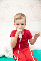 Sad little boy sitting in red t-shirt and almost crying, breathing nebulizer