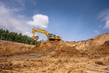 A caterpillar tractor works with a bucket in a sand pit. Sand mining
