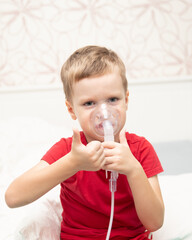 Sad little boy sitting in red t-shirt and almost crying, breathing nebulizer