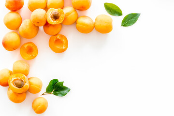 Fruit frame. Apricots and leaves on white background top view copy space