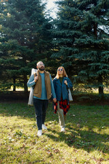 Fototapeta premium Happy couple enjoying a sunny outdoor day with folding chairs in a peaceful green area
