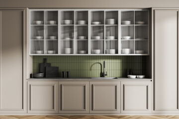 Modern kitchen interior with light cabinets, green tiled backsplash, and minimalist dishware...