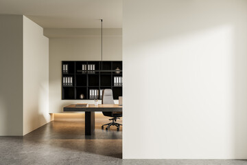 Modern office workspace interior with minimalist desk, shelving, and empty bright wall for poster...