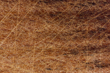 Close-up of scratched brown wooden surface with texture.