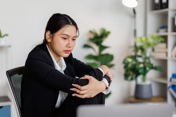 Shot of a young business asian woman looking stressed while working in a modern office
