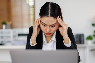 Eco friendly, business asian woman stress or tired in working on laptop while sitting at workplace office.