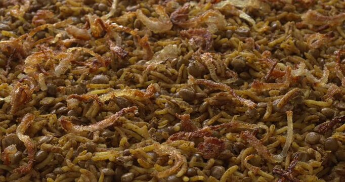Mujaddara, a popular Middle Eastern dish consisting of lentils, rice, caramelized onions, and a lot of spices. Table spin, selective focus.