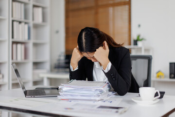 Stressed or sad and tired young business asian woman working with laptop at workplace.
