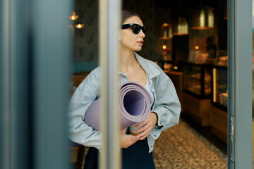 Young female yoga instructor waiting for her group of students
