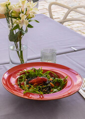 Bright black spaghetti with seafood and succulent crab on fresh rocket, highlighting culinary skill...