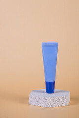 Purple packaging for cream, sunscreen or serum on with stylish props on cream background.