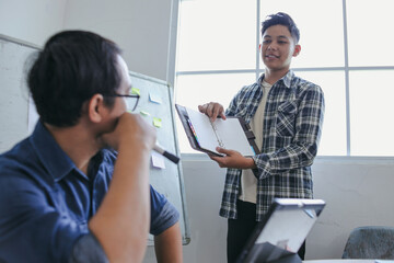Asian Student Presents His Work To Teacher During Learning Session