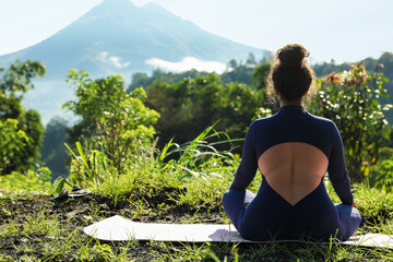 Woman meditating on yoga mat outdoors, back view. Space for text