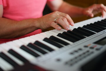 Obraz premium Two hands on electronic piano keyboard, music practice