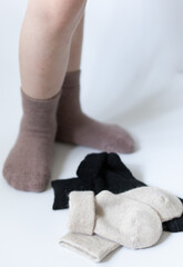 Baby feet in warm brown socks on a white background