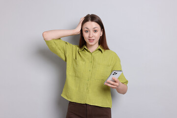 Teenage girl with smartphone on light grey background