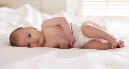 Cute newborn baby lying on bed indoors