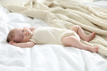 Cute newborn baby sleeping on bed indoors