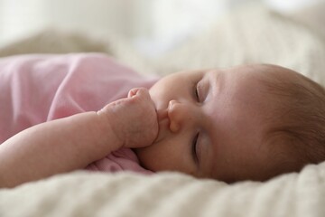 Cute newborn baby sleeping on bed indoors