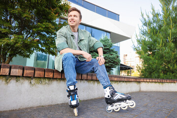 Young man with roller skates on wooden bench outdoors