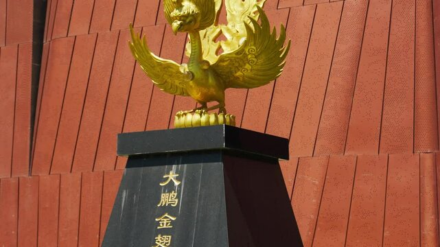 A golden winged Roc statue stands boldly in front of the Yunnan Provincial Museum&mdash;highlighting bold posture, symbolic grandeur, and the cultural resonance of a regional guardian monument.