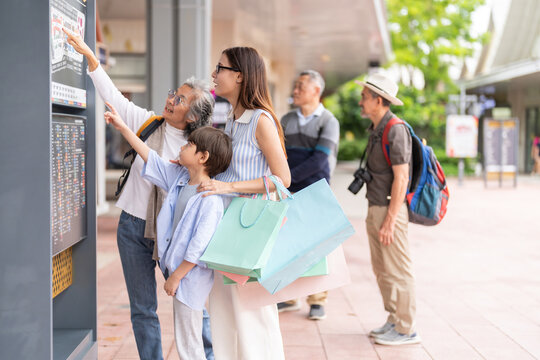 Asian multigenerational family shopping at shopping mall, mother child and grandmother checking screen, enjoying weekend activity holiday trip planning, family lifestyle, shopping cashback promotion