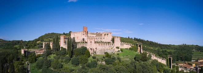 Aerial View of Soave Castle in Verona, Italy: The medieval fortress sits atop a hill, surrounded by battlements and the historic town of Soave, a gem of Italian culture.