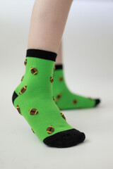 Baby feet in bright green socks on white background