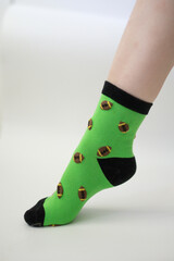 Baby feet in bright green socks on white background