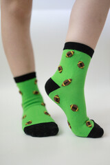 Baby feet in bright green socks on white background