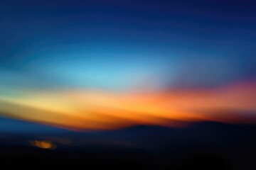 Fototapeta premium Blurry sunset sky over dark mountains